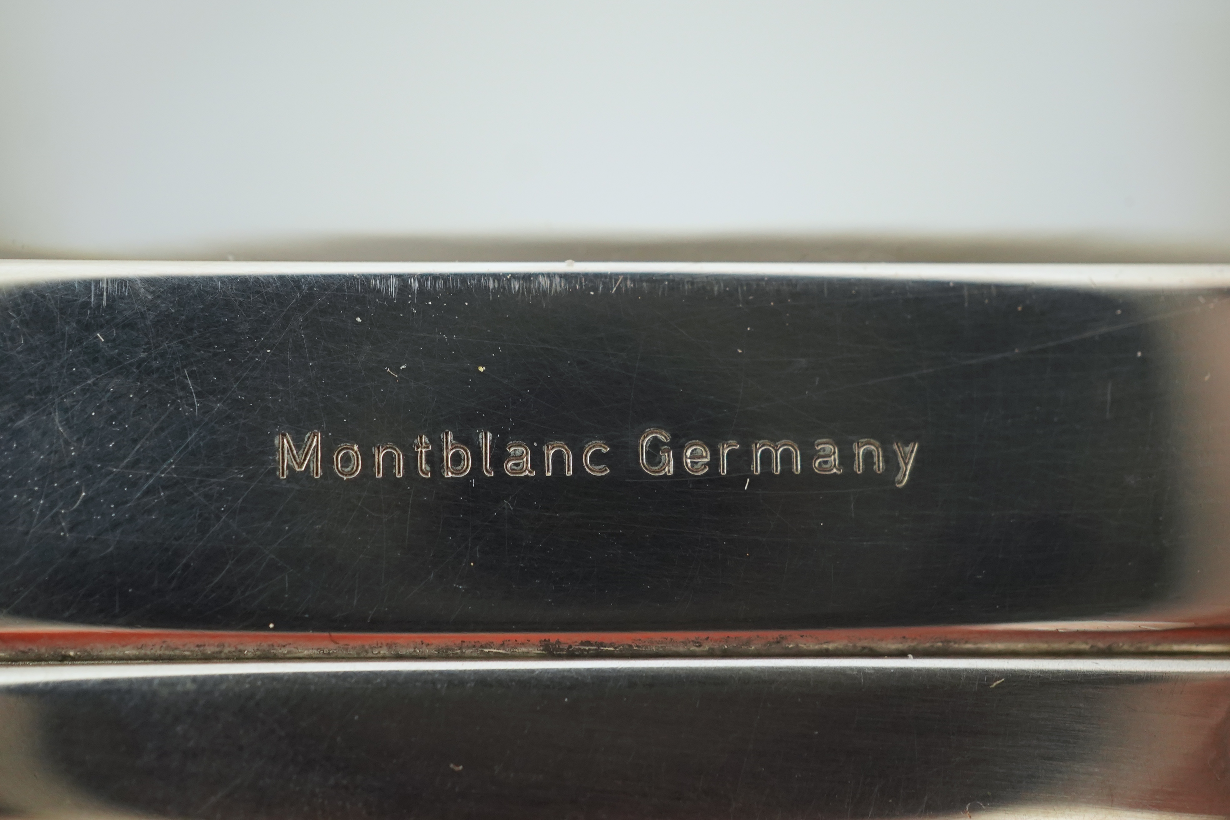 A Montblanc three piece German silver and glass desk set comprising pen stand, inkwell and blotter, each glass mounted, silver engraved with the Montblanc logo